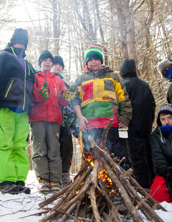 staying warm around the fire in a winter outdoor education program